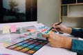 Hand designer choosing colors for doing graphic on laptop Royalty Free Stock Photo