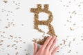 Hand destroying bitcoin sign made from pieces of gold on white background