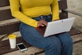 Hand detail african american woman in yellow t-shirt and jeans working her netbook