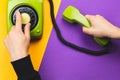 Hand dialing a number on a classic phone with round dial. vintage green telephone with handset on color background. old Royalty Free Stock Photo