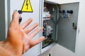 Hand in a dielectric glove on a background of an electrical panel