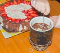 Hand dipped fruit in dessert fondue, close-up. Royalty Free Stock Photo