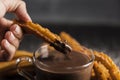 hand dipping fried churros chocolate. High quality photo