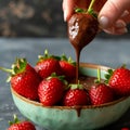 a hand dipping strawberries into chocolate on bowl Royalty Free Stock Photo