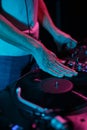 Hip hop dj scratching vinyl record on turntable player. Club disc jockey scratches records on rap concert in nightclub