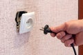 Hand disconnects or connects the plug to a broken outlet, risk of electric shock