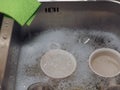 hand dish washing in kitchen sink with detergent foam