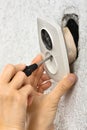 Hand dismantling broken old electric socket