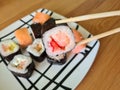 Hand with disposable chopsticks holds sake nigiri sushi with salmon