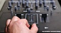 hand on dj mixer crossfader (detail closeup) analog music, super macro, knobs and volume adjusters Royalty Free Stock Photo