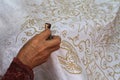 Hand do drawing the white fabric with batik motif using Canting a tool for drawing with wax Royalty Free Stock Photo