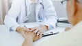 Hand of doctor comforting patient at consulting room