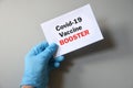 The hand of the doctor hold a white paper with the text `Covid-19 Vaccine Booster`. Concept of Combating the COVID-19 Virus with Royalty Free Stock Photo