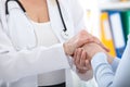 Hand of doctor reassuring her female patient. Medical ethics and trust concept. Handshake, hands closeup Royalty Free Stock Photo