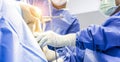 Hand of doctor or surgeon in blue gown inside operating room during osteomy in total knee joint replacement surgery Royalty Free Stock Photo