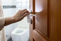 Hand with door handle,girl open the bathroom door,woman using tissue paper to touch the door knob instead of hands to prevent Royalty Free Stock Photo