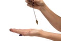 Hand of dowser with hand-held pendulum over the arm. Royalty Free Stock Photo