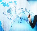 A hand is drawing the digital business world. The world map is drawn over the digital globe. Royalty Free Stock Photo