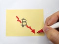 Hand drawing at a downward graph depicting bitcoin plunge Royalty Free Stock Photo