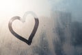 Hand drawing heart on frozen window with natural sunlight Royalty Free Stock Photo