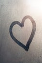 Hand drawing heart on frozen window with natural sunlight Royalty Free Stock Photo