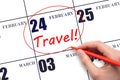 Hand drawing a red circle and writing the text TRAVEL on the calendar date 24 February. Travel planning.