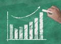 Hand drawing rising curve chart on blackboard illustrating business success or rising stock prices