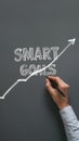 Hand drawing SMART GOALS line graph on gray background, symbolizing progress and productivity