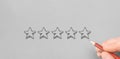 hand drawing 5 stars five stars rating on grey paper. Customer hand review feedback five star rating service or product quality