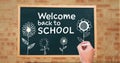 Hand drawing Welcome back to school text and flowers on blackboard Royalty Free Stock Photo