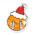 hand drawn distressed sticker cartoon of a orange wearing santa hat