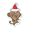 hand drawn distressed sticker cartoon of a suspicious monkey wearing santa hat
