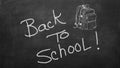 Hand drawn doodle Back to School words and school bag on black chalkboard. Royalty Free Stock Photo