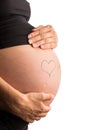Hand-drawn heart on the bare swollen belly of a pregnant woman
