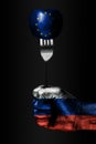 A hand with a drawn Russia flag holds a fork, on which is a ball with a drawn EU flag, a sign of influence, pressure, grip and