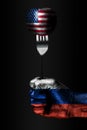 A hand with a drawn Russia flag holds a fork, on which is a ball with a drawn USA flag, a sign of influence, pressure, grip and