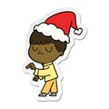 hand drawn sticker cartoon of a grumpy boy wearing santa hat