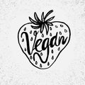 Hand drawn strawberry with text Vegan on grunge background.