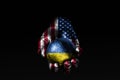 A hand with a drawn USA flag holds a ball with a drawn Ukraine flag, a sign of influence, pressure or conservation and protection