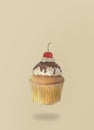 Hand-drawn watercolor of cupcakes is flying on brown background