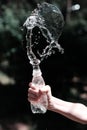 Hand with drinking water pours water