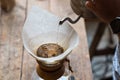 Hand drip coffee, Barista pouring water on coffee ground with filter on wooden table, vintage style Royalty Free Stock Photo