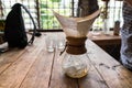 Hand drip coffee, Barista pouring water on coffee ground with filter on wooden table, vintage style Royalty Free Stock Photo