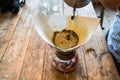 Hand drip coffee, Barista pouring water on coffee ground with filter on wooden table, vintage style Royalty Free Stock Photo