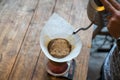 Hand drip coffee, Barista pouring water on coffee ground with filter on wooden table, vintage style Royalty Free Stock Photo