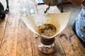 Hand drip coffee, Barista pouring water on coffee ground with filter on wooden table, vintage style Royalty Free Stock Photo