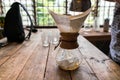 Hand drip coffee, Barista pouring water on coffee ground with filter on wooden table, vintage style Royalty Free Stock Photo