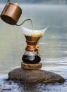Hand drip coffee on the rocks at the river Royalty Free Stock Photo
