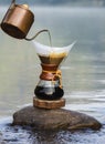 Hand drip coffee on the rocks at the river