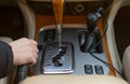 The hand of the driver of the car holding the brake lever, on the background of the automatic transmission controls Royalty Free Stock Photo